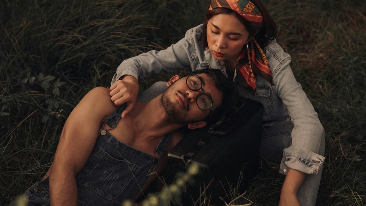A couple sharing a tender moment outdoors, embodying romance and leisure in a fall setting.