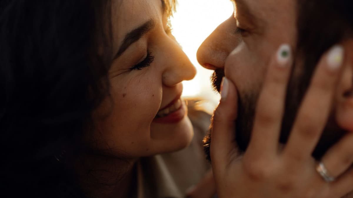 A close-up shot of a happy couple sharing an intimate moment at sunset, showcasing romance and connection.